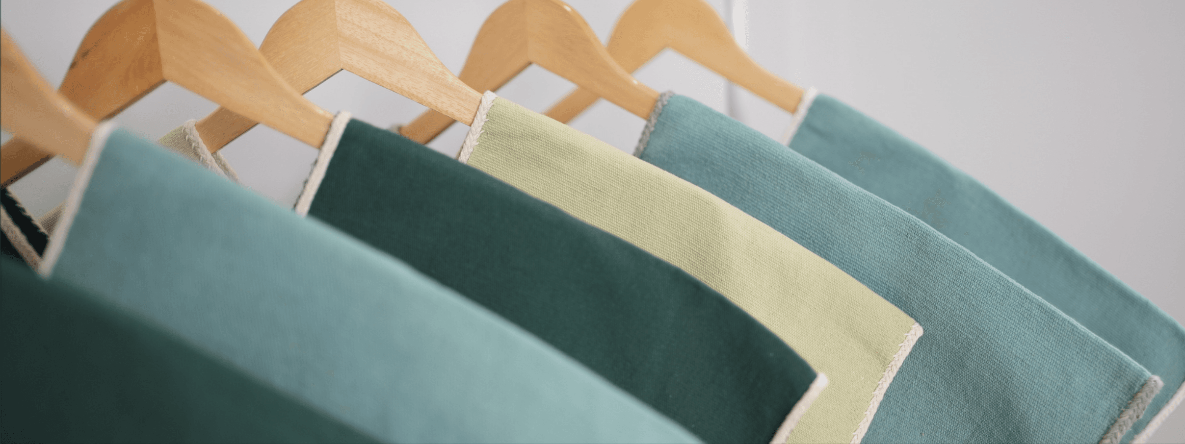Folded fabric swatches on wooden hangers